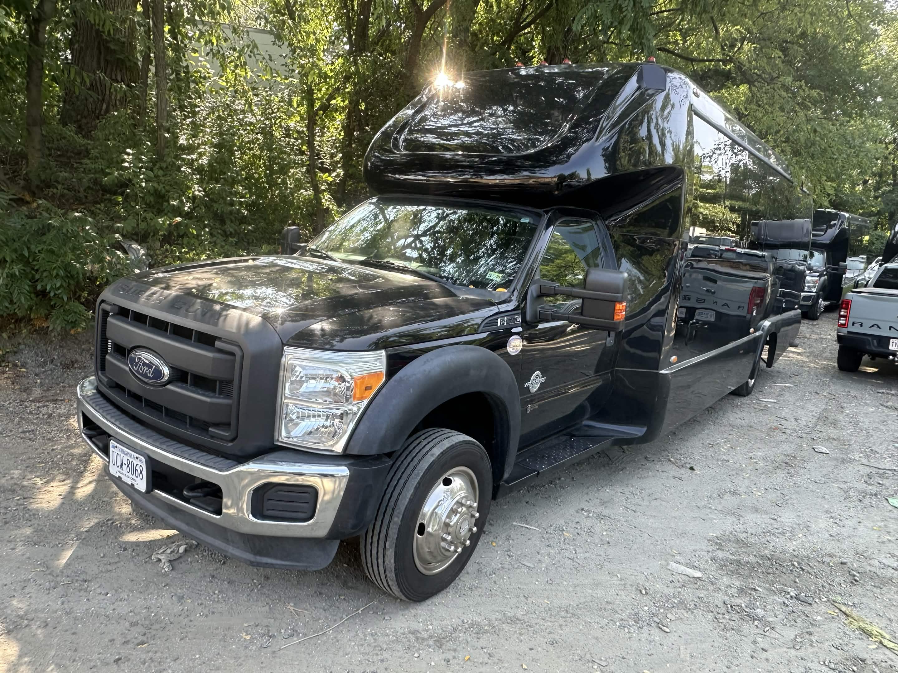 Black executive mini coach bus, front three-quarter exterior view