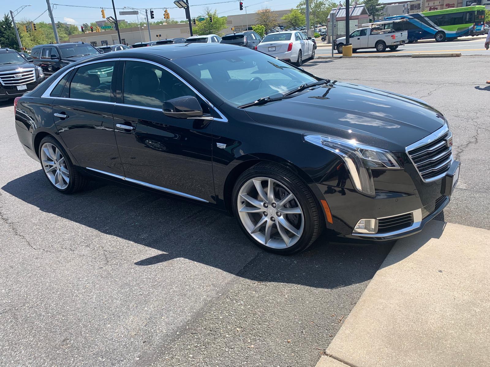 Black Cadillac XTS executive sedan parked, side profile view